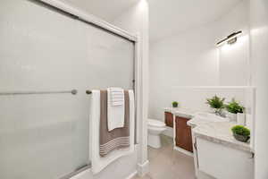 Bathroom with vanity, light tile patterned floors, and enclosed tub / shower combo