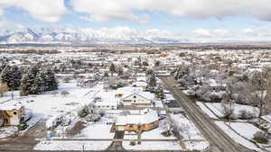 Snowy aerial view featuring a residential view and a mountain view