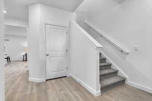 Staircase featuring wood finished floors