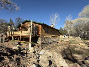 Back of house with a chimney and a deck