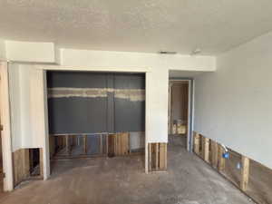 Spare room featuring a textured ceiling and concrete floors