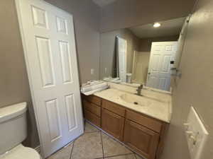 Half bathroom with vanity and light tile patterned floors