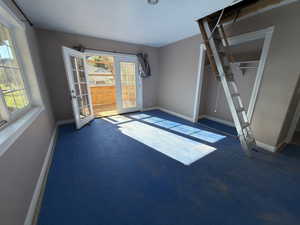 Unfurnished living room with baseboards and dark carpet