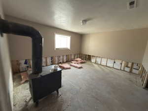 Living room featuring a wood stove and a textured ceiling