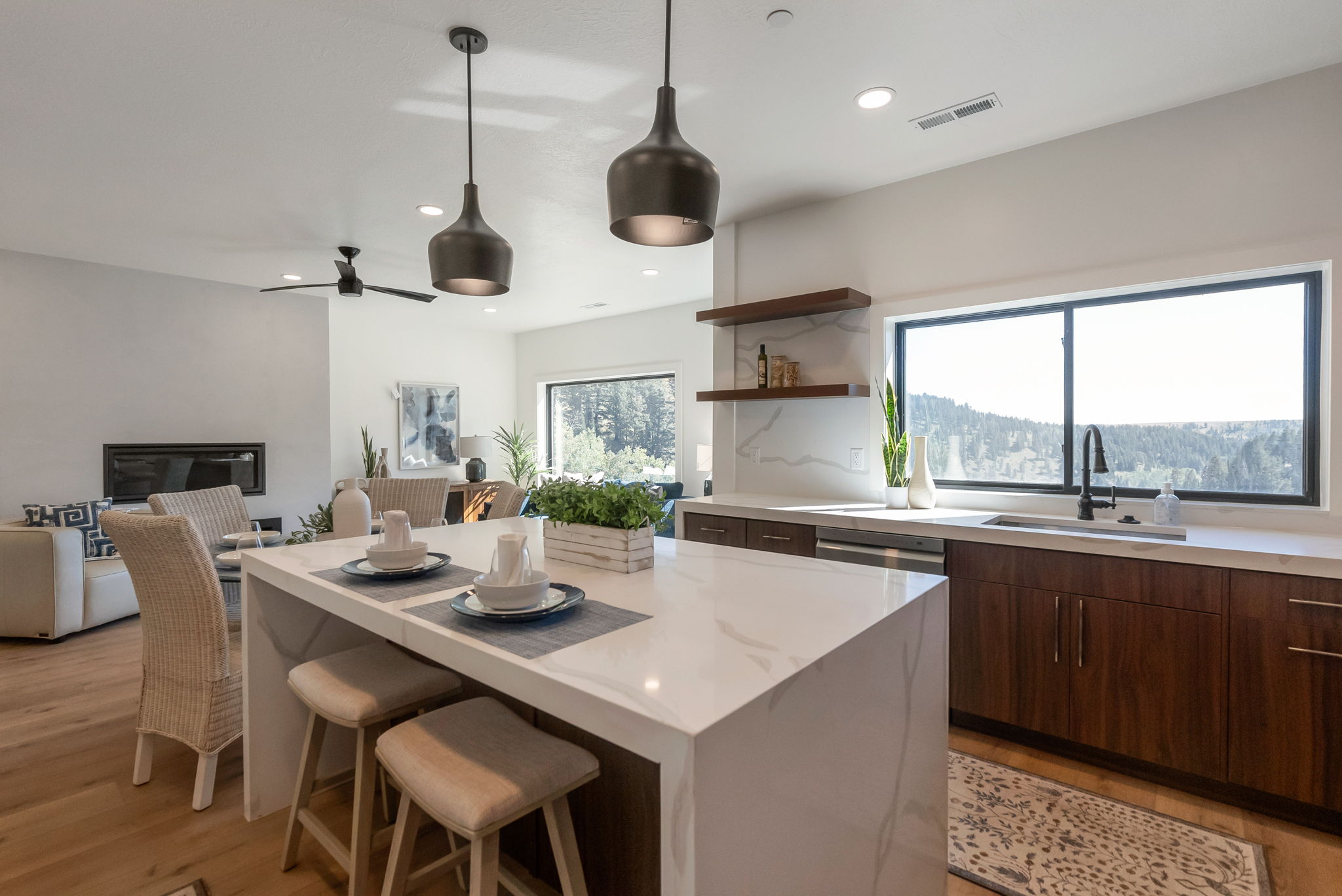 Kitchen with a breakfast bar, open floor plan, hanging light fixtures, light stone countertops, and a center island