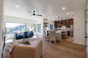 Living area with recessed lighting, ceiling fan, and light wood-type flooring