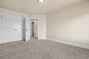 Unfurnished bedroom with light colored carpet and a closet