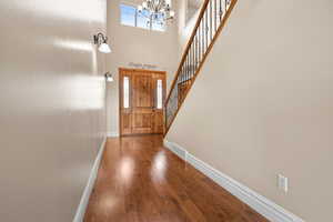 Foyer featuring a high ceiling, dark wood finished floors, and hanging lights