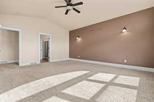 Unfurnished bedroom with light colored carpet, vaulted ceiling, and ceiling fan