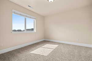 Spare room featuring light carpet and baseboards
