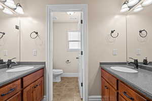 Bathroom with two vanities and light tile patterned floors