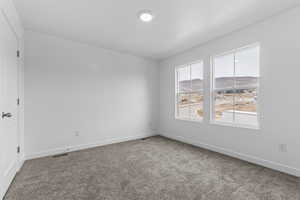 Spare room featuring carpet floors and baseboards