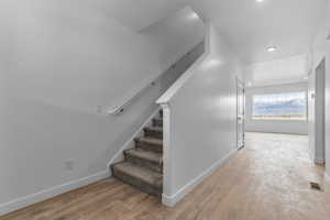 Stairway with hardwood / wood-style floors and recessed lighting