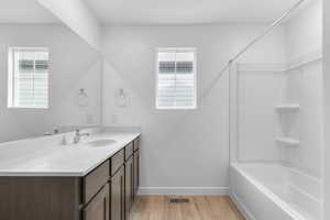 Bathroom with vanity, light wood-style floors, and bathtub / shower combination