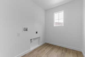 Laundry area featuring light wood-type flooring, hookup for an electric dryer, hookup for a washing machine, and lofted ceiling