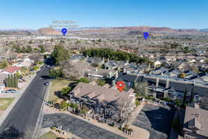 Aerial view of property and surrounding area with a mountainous background and nearby suburban area