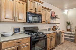 Kitchen featuring black appliances, light countertops, and wine cooler