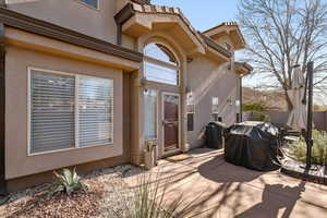 View of exterior entry featuring a patio and stucco siding