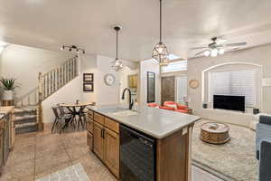 Kitchen with open floor plan, black dishwasher, a center island with sink, a ceiling fan, and rail lighting