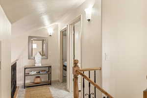 Corridor featuring light colored carpet and an upstairs landing