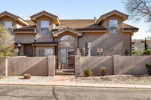 View of front of property featuring a fenced front yard, a gate, stucco siding, and a tiled roof