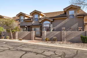 View of front of property featuring a fenced front yard, a gate, stucco siding, and a tile roof