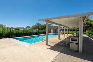 Community pool featuring a patio and an outbuilding