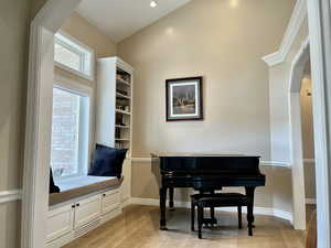 Entry way sitting room with arched walkways and light wood finished floors