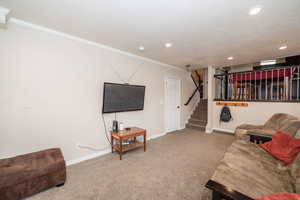 Carpeted living area featuring ornamental molding and recessed lighting