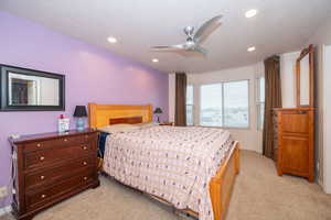 Bedroom with light carpet, a ceiling fan, and recessed lighting
