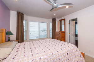 Carpeted bedroom with a ceiling fan, a textured ceiling, and recessed lighting