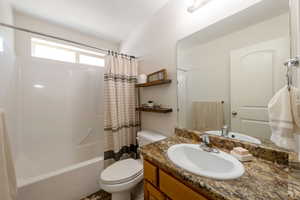 Bathroom featuring vanity and shower / bath combination with curtain