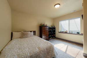 Bedroom with light colored carpet and a textured ceiling