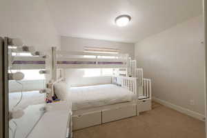 Bedroom featuring light colored carpet and baseboards
