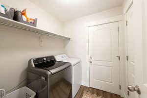 Laundry room featuring independent washer and dryer and dark wood-type flooring