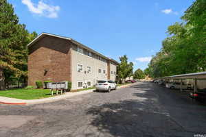 View of asphalt street featuring sidewalks and curbs