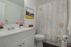 Full bathroom with vanity, wood finished floors, and shower / tub combo with curtain