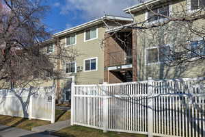 Rear view of property with a fenced front yard and a balcony
