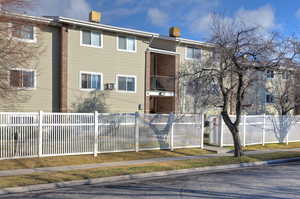 View of apartment building / complex with a fenced front yard