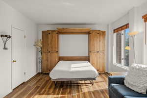 Bedroom with wood finished floors and baseboards