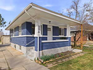 View of front facade featuring a porch and a storage shed