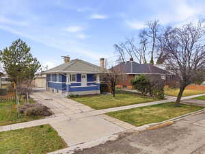 View of front of property with a chimney, concrete driveway, and brick siding