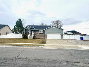 Single story home featuring concrete driveway and a garage