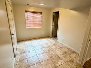 Empty room featuring baseboards and light tile patterned floors