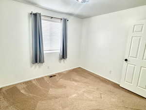 Unfurnished room with a textured ceiling and carpet