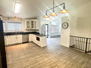 Kitchen featuring glass insert cabinets, dark countertops, white cabinets, finished floors, and freestanding refrigerator