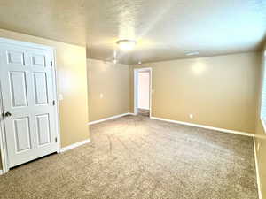 Basement Bedroom with carpet and a textured ceiling