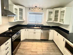 Kitchen with glass insert cabinets, stainless steel appliances, white cabinets, and tiled floors