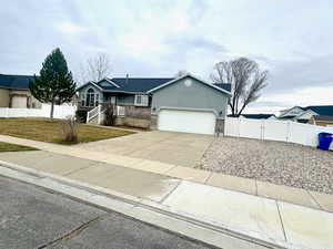Ranch-style home with concrete driveway, a garage, stucco siding, and stone siding