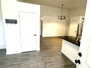 Unfurnished dining area featuring finished floors and baseboards